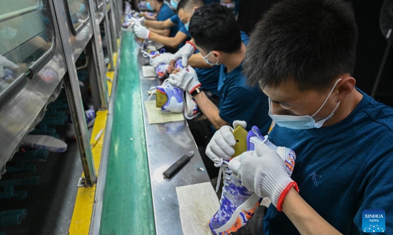 Staff members work on a production line in a sports shoe company in Jinjiang City, southeast China's Fujian Province, May 14, 2022.Photo:Xinhua